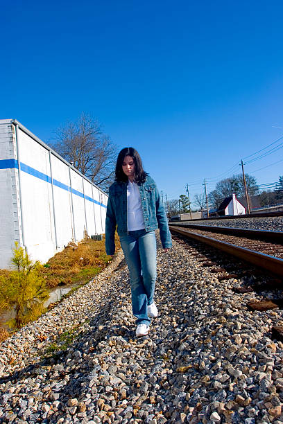 Teen Girl Walking by the Train Tracks stock photo