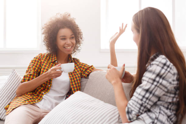 istock Two young female friends with coffee conversing 906712460