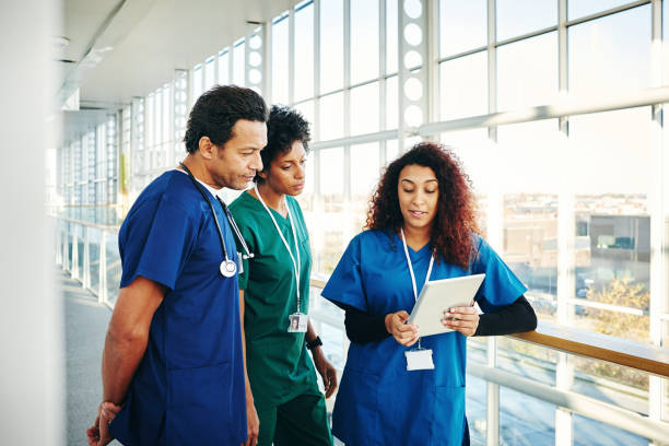 istock Surgeons discussing over digital tablet in hospital corridor 906716446
