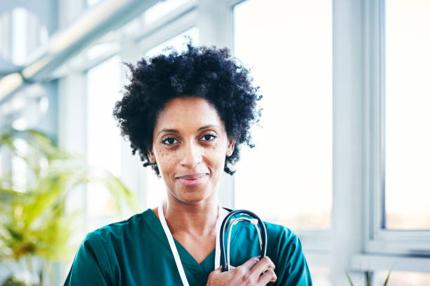 Happy female healthcare worker in hospital Close up of happy young female healthcare worker standing in hospital female role model stock pictures, royalty-free photos & images