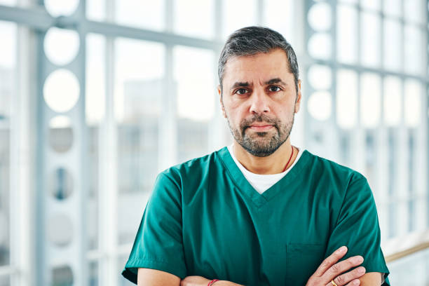 zuversichtlich männlichen chirurg in scrubs - doctor male doctor mature men portrait stock-fotos und bilder