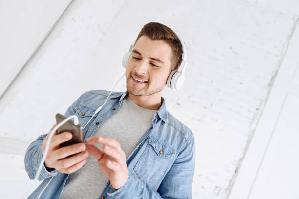 istock Cheerful male person using his gadget with pleasure 906719828