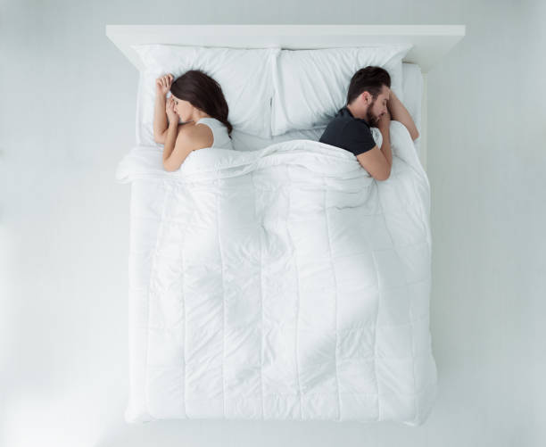 Couple sleeping in bed Young couple sleeping in bed back to back, top view man sleeping top view stock pictures, royalty-free photos & images