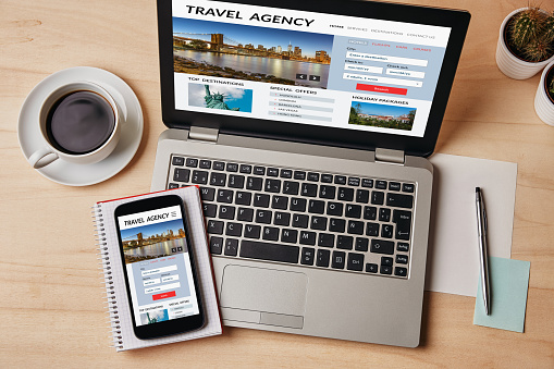 Concepto de agencia de viajes en la pantalla del ordenador portátil y smartphone photo