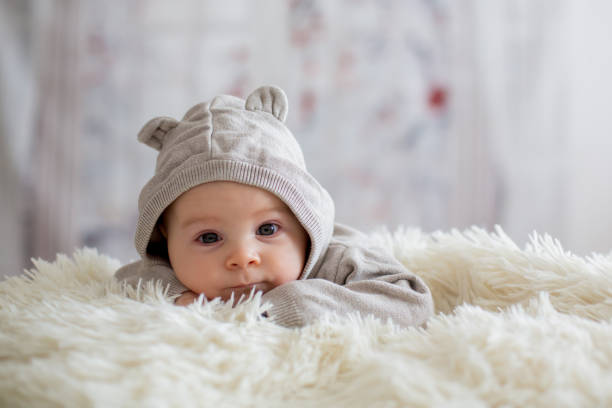 istock Sweet baby boy in bear overall, sleeping in bed with teddy bear 906735130