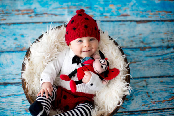 istock Little baby boy with knitted ladybug hat and pants in a basket 906735368