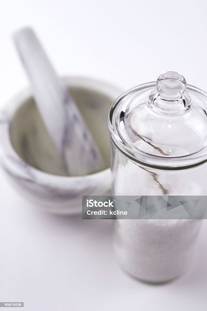 Mortar Pestle Jar Mortar & pestle with an apothecary jar filled with coarse sea salt.  This combination cna be used for either culinary applications or spa and homeopathic applications such as sea salt soaks to melt away achey muscles. Color Image Stock Photo