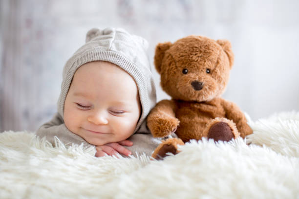 istock Sweet baby boy in bear overall, sleeping in bed with teddy bear 906740908
