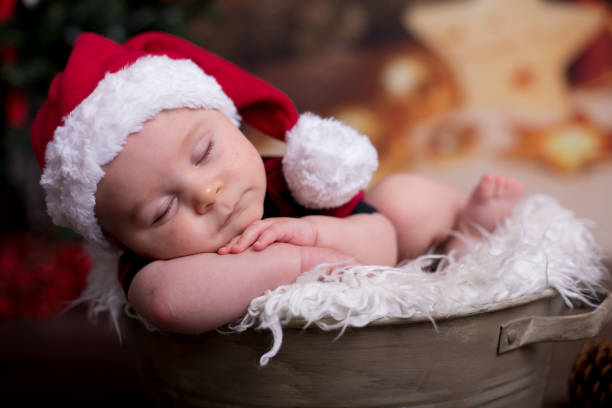 istock Little baby boy with christmas clothes, sleeping in basket 906752690