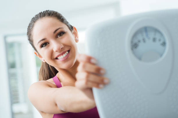 istock Happy woman showing a scale 906758510