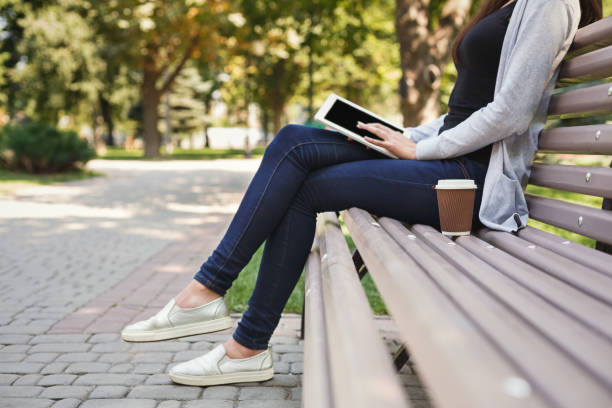 istock Unrecognizable woman typing on tablet outdoors 906759008