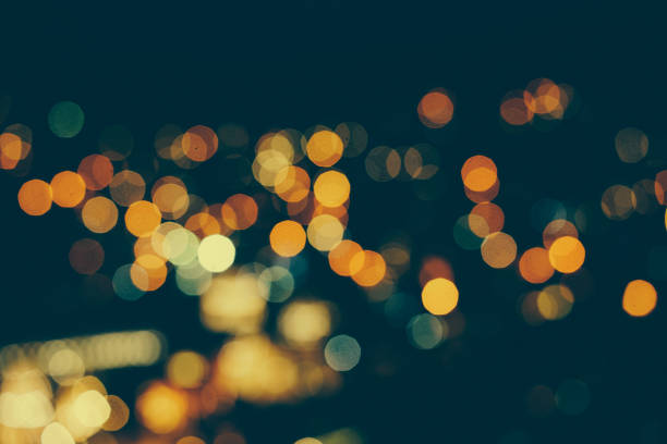 Defocused urban abstract texture bokeh city lights & traffic jams in the background with blurring lights on the top of mountain.