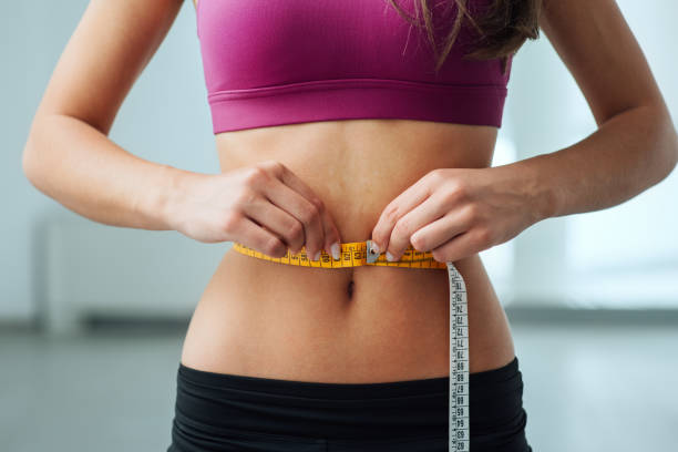 istock Slim woman measuring her thin waist 906761356
