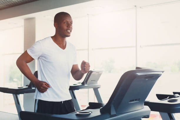 istock Young man in gym run on treadmill 906761364