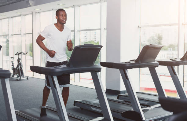 istock Young man in gym run on treadmill 906761786