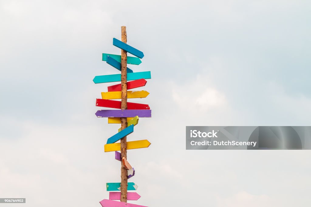 Colorful wooden direction arrow signs Colorful wooden direction arrow signs on a wooden pole Direction Stock Photo