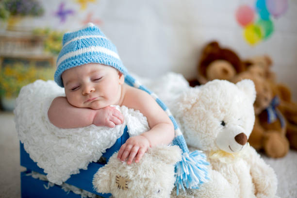 istock Little baby boy with knitted hat, sleeping with cute teddy bear 906765506