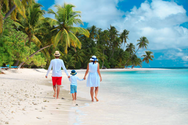 istock family with child walking on beach 906772406