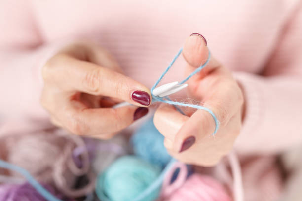 istock Knitting baby things, close up colored clew in hand 906772872