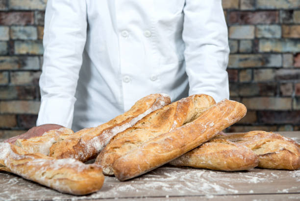 istock baker with traditional bread french baguettes 906774316