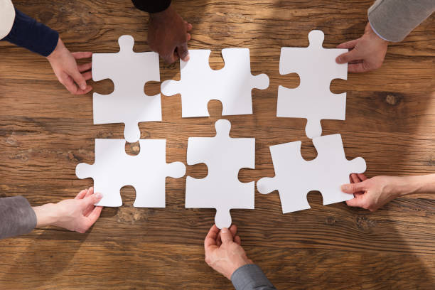 istock Businesspeople Arranging The Puzzle 906777462