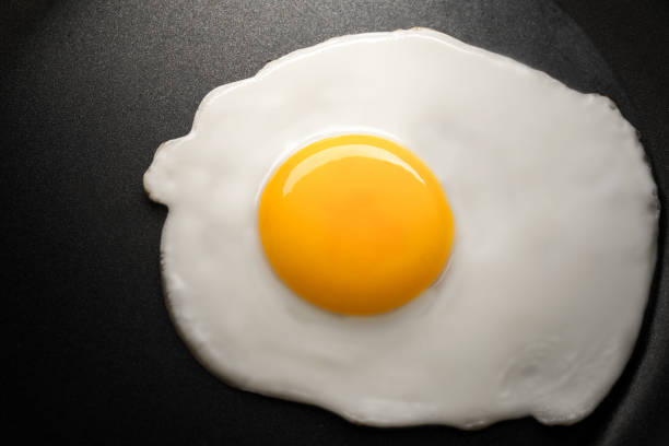 istock close up fried egg on frying black pan 906778478