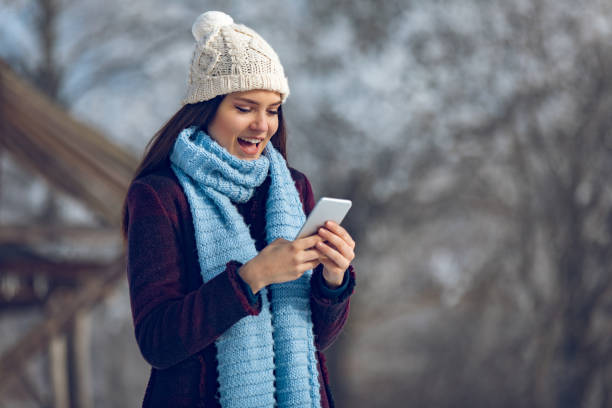 istock Young woman with mobile phone in winter landscape 906782714