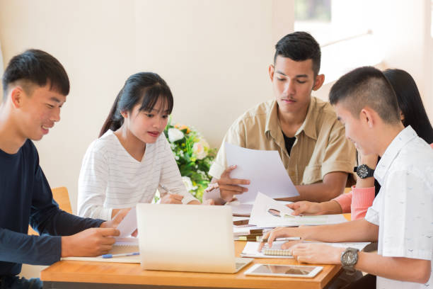 istock Asian College groups of students using laptop, tablet, studying together with notebooks documents paper and charts for report in class. Young study for projected learning assignment, Education Concept 906782728