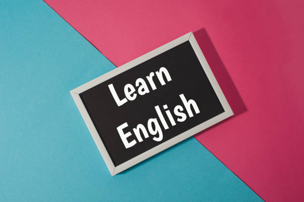 istock Learn English - text on chalkboard on blue and pink bright background. 906783084