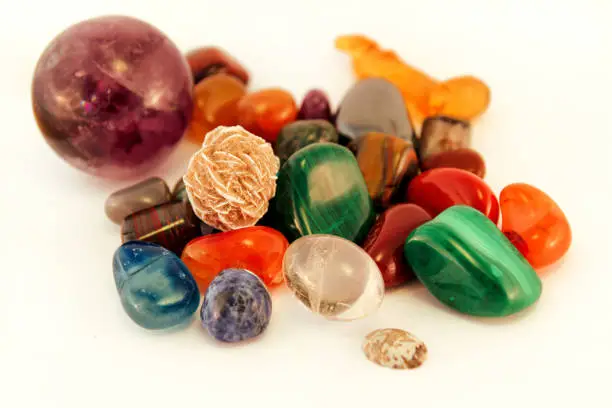 Semi precious stones / Crystal Stone Types / healing stones, worry stones, palm stones, ponder stones / Various stones gemstones background texture / Heap of various colored gems mineral collection.