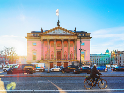 Berlin, Germany - December 13, 2017: Man on bicycle on Unter den Linden at Berlin State Opera in Berlin, Germany