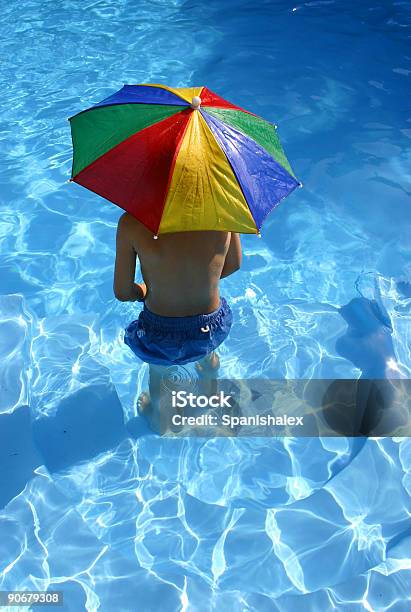 Rapaz Com Guardachuva Na Piscina - Fotografias de stock e mais imagens de Abaixo - Abaixo, Com sombra, Guarda-chuva