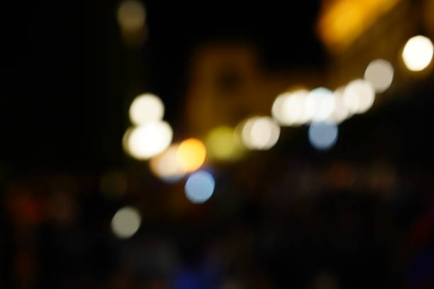 Defocused urban abstract texture bokeh city lights & traffic jams in the background with blurring lights on the top of mountain.