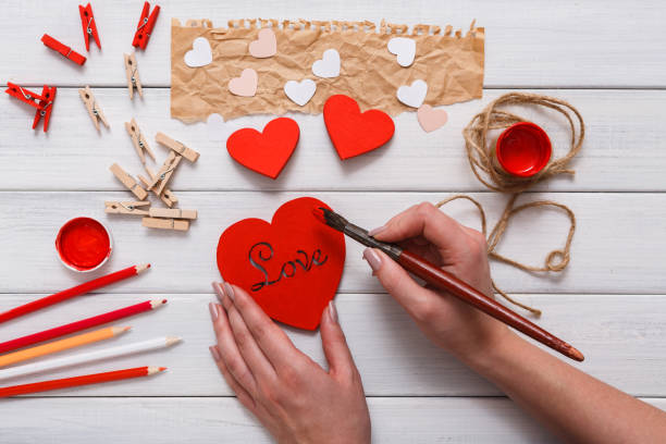 istock Valentine day diy handmade hearts making, top view on wood 906798110
