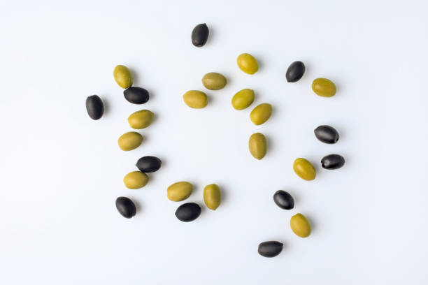 scattered green and black olives Top view of scattered unprocessed green and black olives isolated on white olive tree cut out stock pictures, royalty-free photos & images