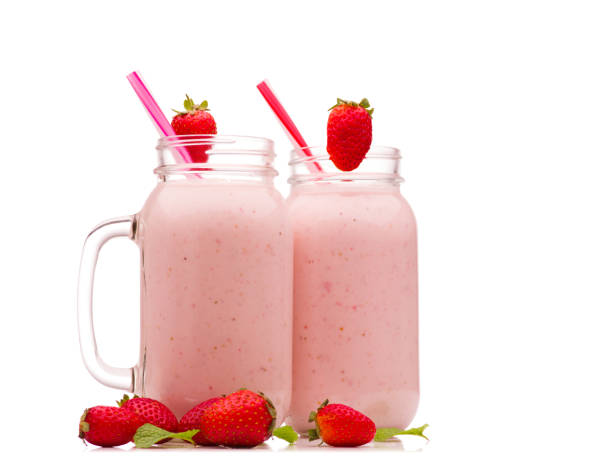 istock Smoothies in two jar with cocktail straws and strawberries and blueberries. Isolated on white background. 906801862