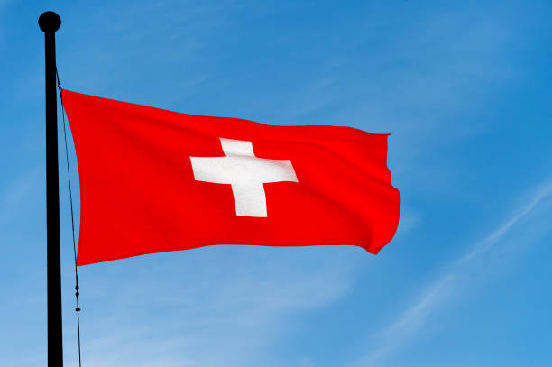 istock Swiss Flag waving over blue sky (3D rendering) 906808258