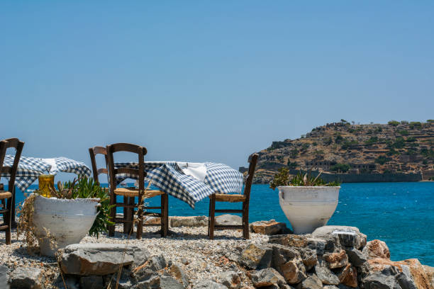 istock Several tables with tablecloth and chairs near the blue water 906820054