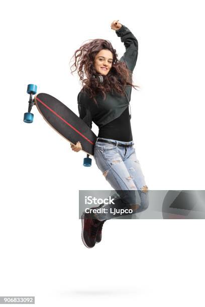 Encantado De Chica Adolescente Con Un Longboard De Salto Foto de stock y más banco de imágenes de Monopatín - Actividades recreativas