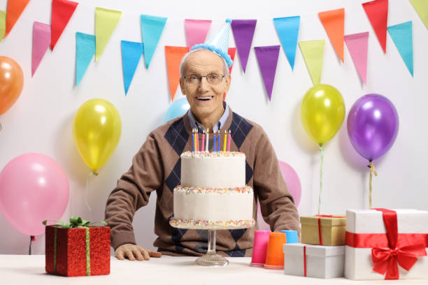 istock Happy senior with a birthday cake 906834384