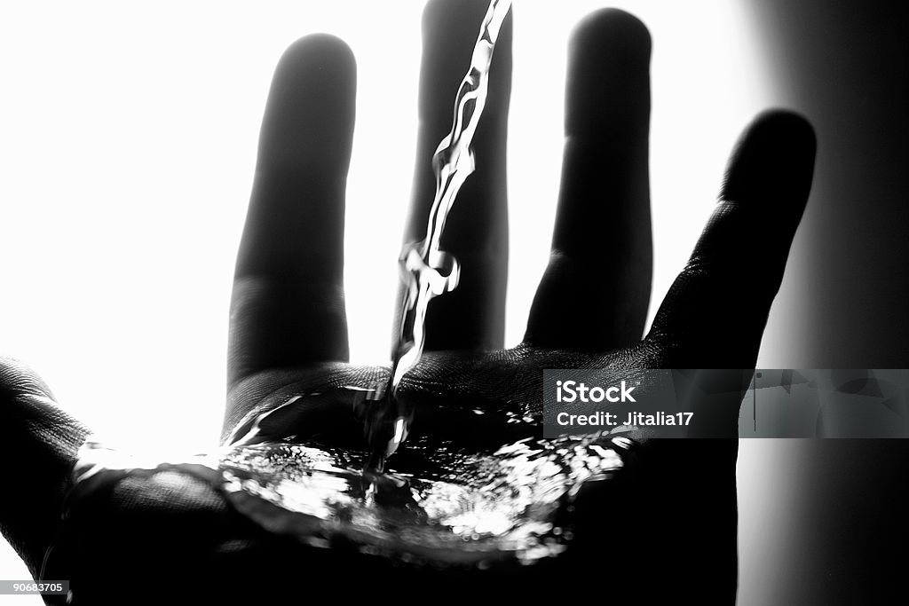 Acqua versare nel palmo della mano dell'uomo-B & W - Foto stock royalty-free di Lavarsi le mani