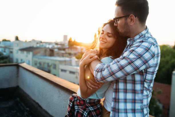 istock Happy couple enjoying drinks and balcony 906837094