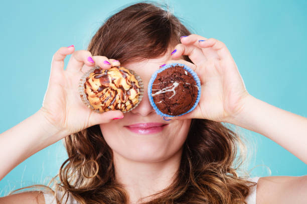 istock Smiling crazy woman holds cakes in hand 906840934