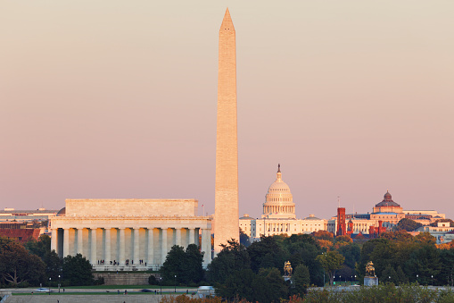 Skyline of Washington DC at sunset featuring the Lincoln memorial, Washington monument and the US Capitol building.