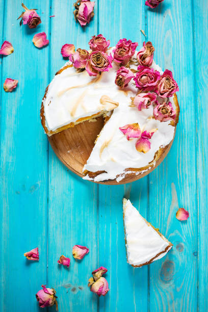 istock The white cream cake decorated dry rose on blue wood background. 906865990