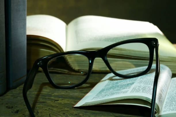 istock Open Bible with Glasses on the Old Table. 906870278