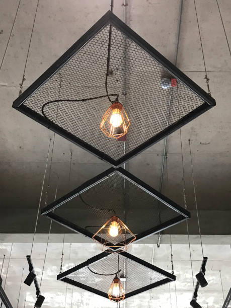 istock Row of bare modern hanging lamps under cement ceiling 906870610