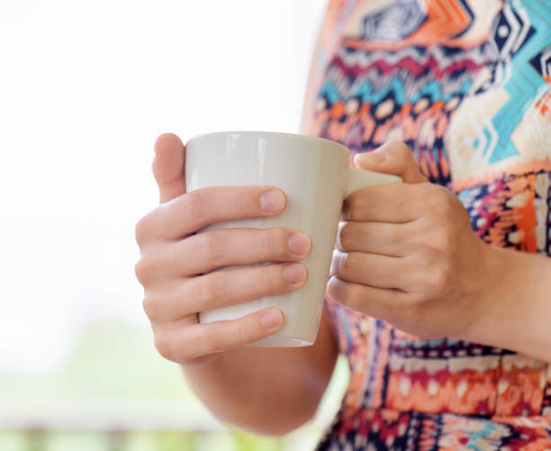 istock Young woman enjoying a mug of beverage. 906875164
