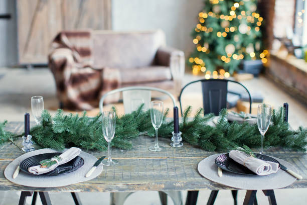 istock Rustic Christmas served table with vintage silverware, candles and fir twigs 906875376