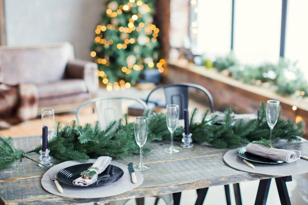 istock Rustic Christmas served table with vintage silverware, candles and fir twigs 906875486
